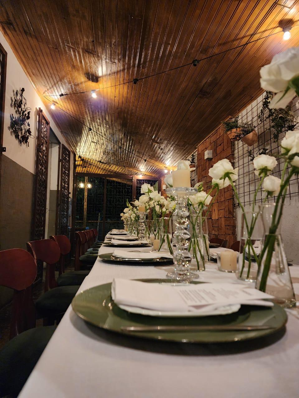 Mesa longa decorada com flores brancas e velas