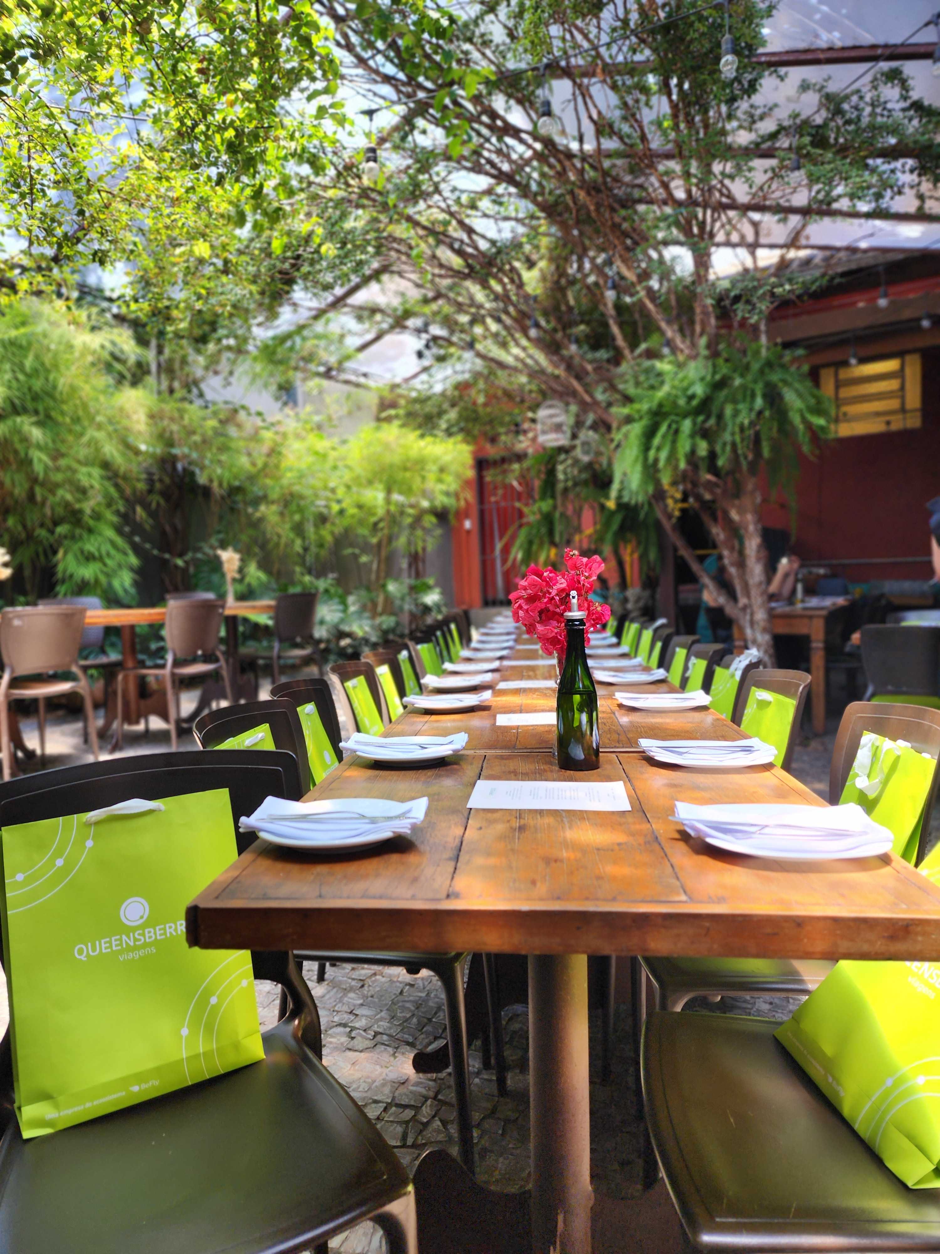 Mesa preparada no jardim do Paradiso com flores vermelhas